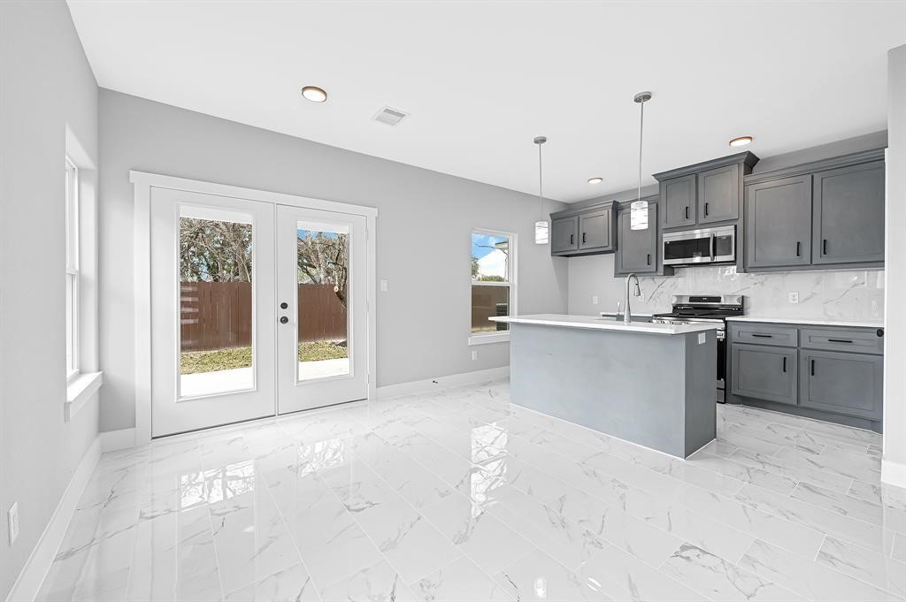 7517 Hezekiah Lane, Unit A Houston, TX 77088 - Photo 6 of 13 a view of kitchen with stainless steel appliances granite countertop a stove top oven a sink refrigerator and cabinets