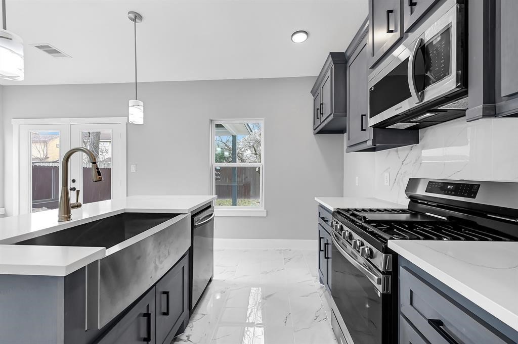 7517 Hezekiah Lane, Unit A Houston, TX 77088 - Photo 7 of 13 a kitchen with stainless steel appliances granite countertop a sink stove and microwave
