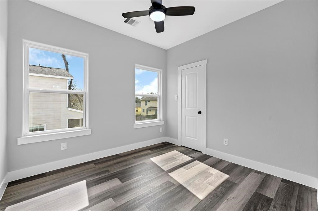 7517 Hezekiah Lane, Unit A Houston, TX 77088 - Photo 10 of 13 a view of an empty room with wooden floor and a window