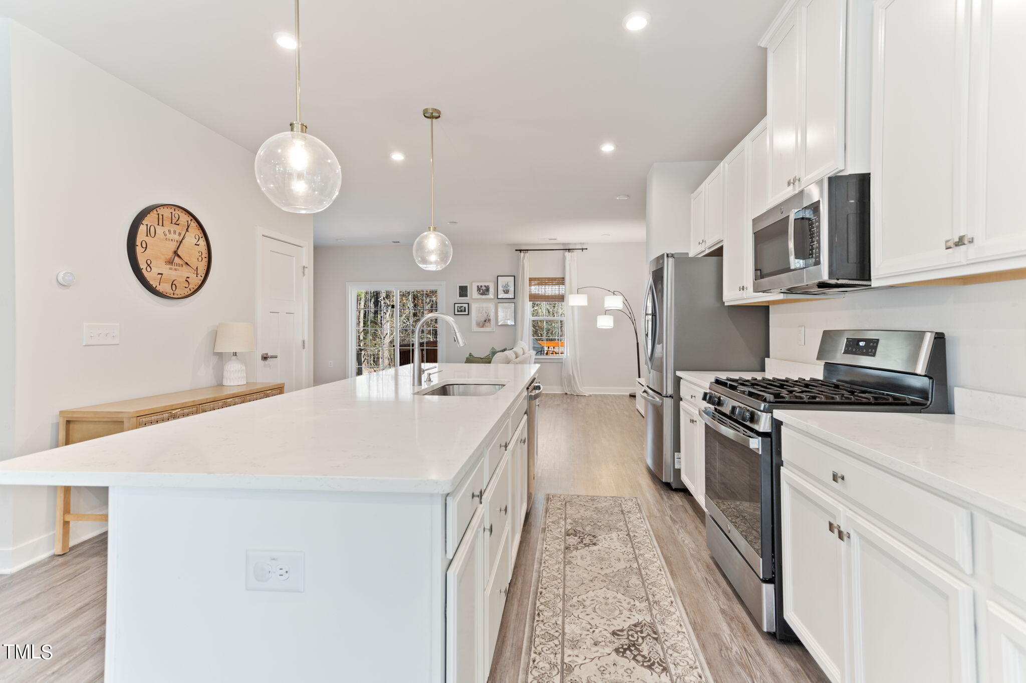 4765 Randall Road Durham, NC 27707 - Photo 9 of 30 a large kitchen with stainless steel appliances a stove oven a sink dishwasher and white cabinets with wooden floor