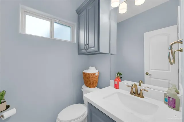 a bathroom with a sink a toilet and a window