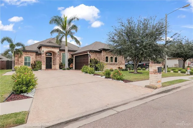 a front view of a house with a yard and potted plants