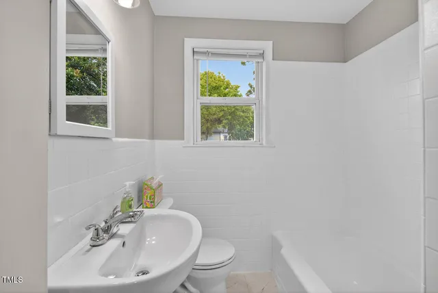 a bathroom with a sink a toilet and a window