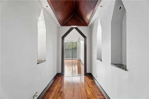 a view of a hallway with wooden floor and staircase
