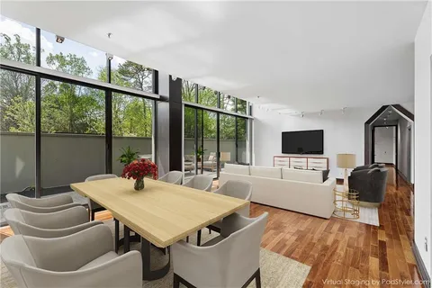 a living room with furniture a flat screen tv and a floor to ceiling window