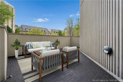 a view of a building with a garden and sitting area