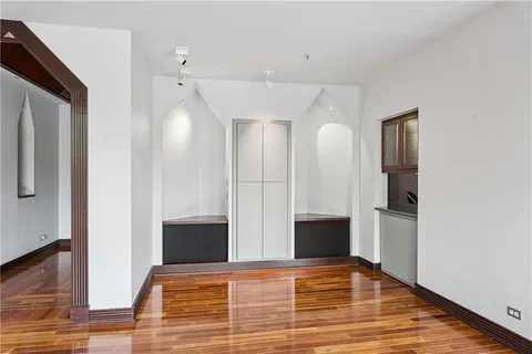 a view of a livingroom with wooden floor and staircase