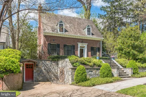 a backyard of a house with table and chairs under an umbrella