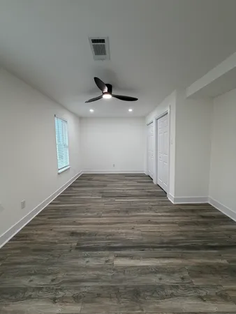 a view of empty room with wooden floor