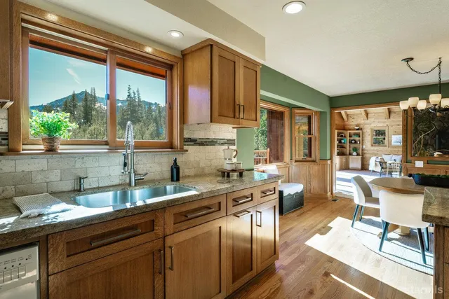 a kitchen with stainless steel appliances granite countertop sink stove and wooden cabinets