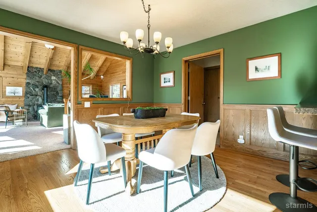 a view of a dining room with furniture a chandelier and wooden floor