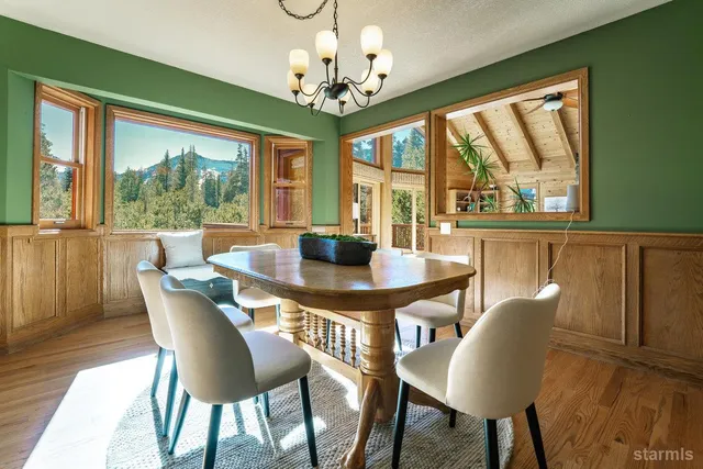 a dining room with furniture a chandelier and wooden floor