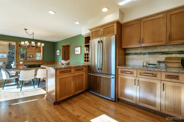 a kitchen with stainless steel appliances granite countertop a refrigerator a sink and a stove top oven