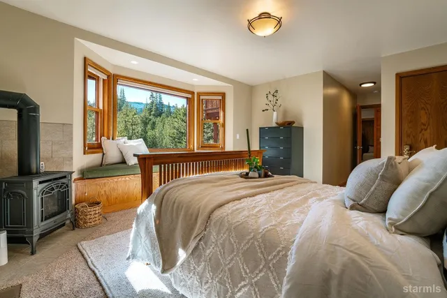 a bedroom with a bed and large windows