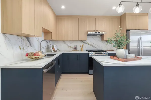 a kitchen with kitchen island granite countertop a sink a stove and cabinets