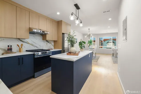 a kitchen with kitchen island a sink dishwasher stove and oven with wooden floor