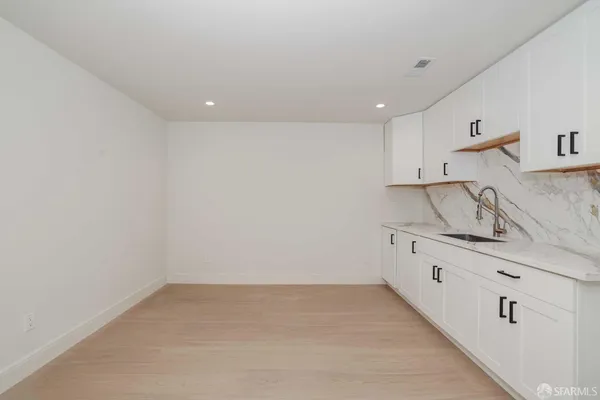 a kitchen with granite countertop white cabinets and a sink