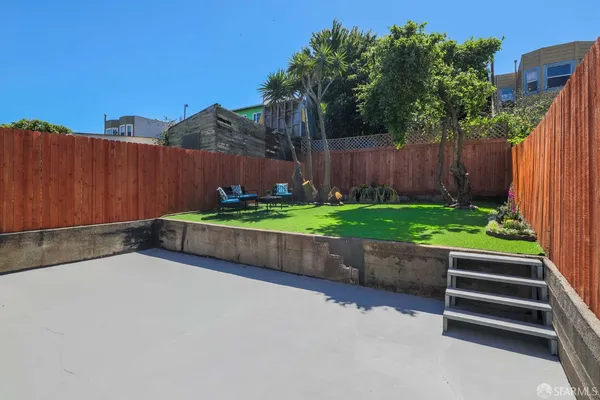 a view of a backyard with wooden fence