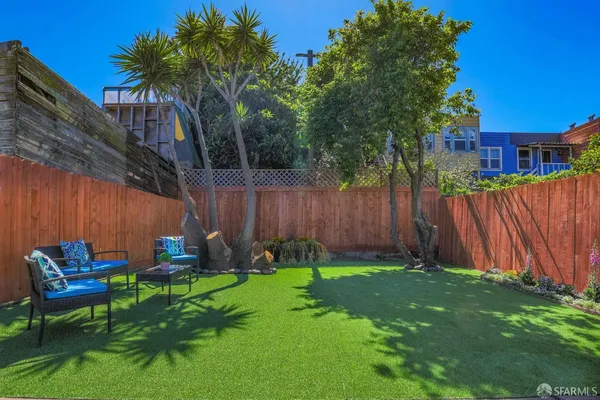a view of a chair and table in backyard of the house
