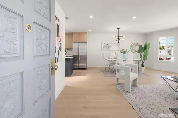 a view of a kitchen with refrigerator and chairs
