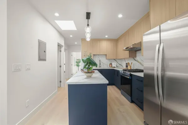 a kitchen with kitchen island a sink stainless steel appliances and cabinets