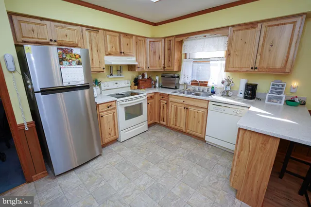 a kitchen with a refrigerator sink and cabinets