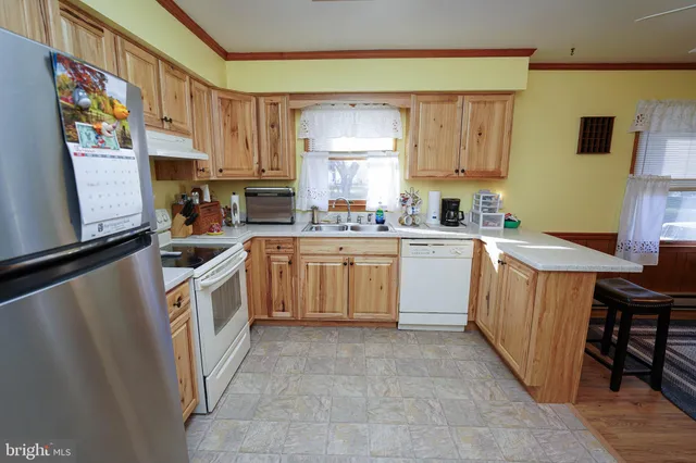 a kitchen with a sink a counter top space cabinets and stainless steel appliances