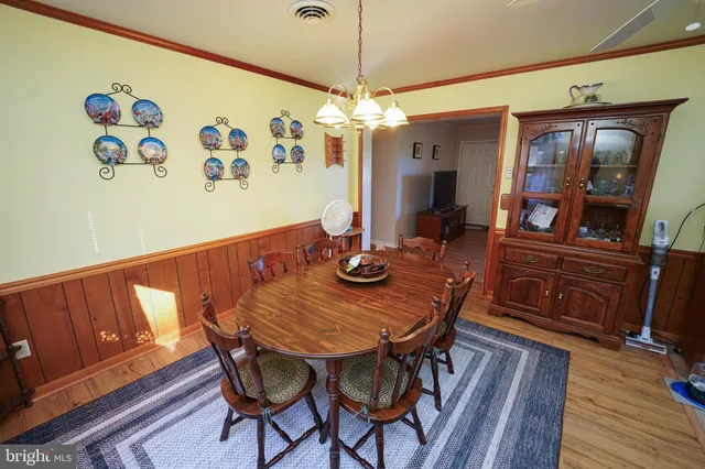 a view of a dining room with furniture wooden floor and chandelier