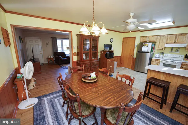 a view of a dining room with furniture a chandelier and wooden floor