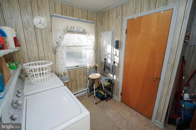 a utility room with wooden floor washer and dryer