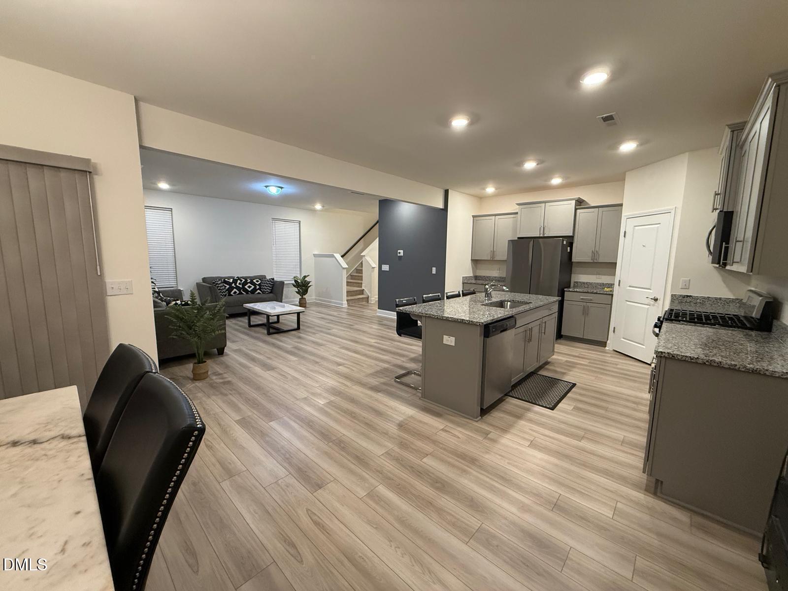 64 Nailsworth Street Angier, NC 27501 - Photo 6 of 14 a kitchen with stainless steel appliances kitchen island granite countertop a sink and a refrigerator