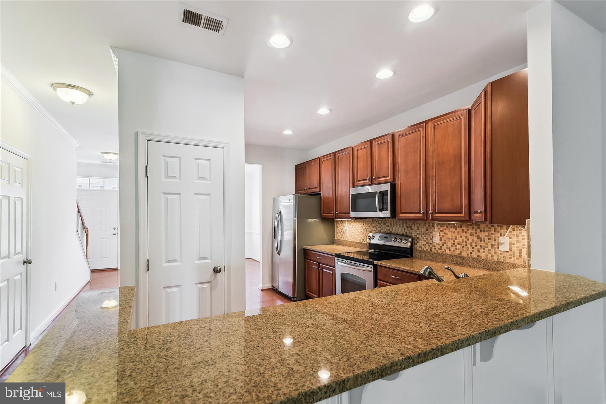 36311 Ridgeshore Lane Millville, DE 19967 - Photo 5 of 36 a kitchen with stainless steel appliances granite countertop a refrigerator a stove top oven a sink and dishwasher