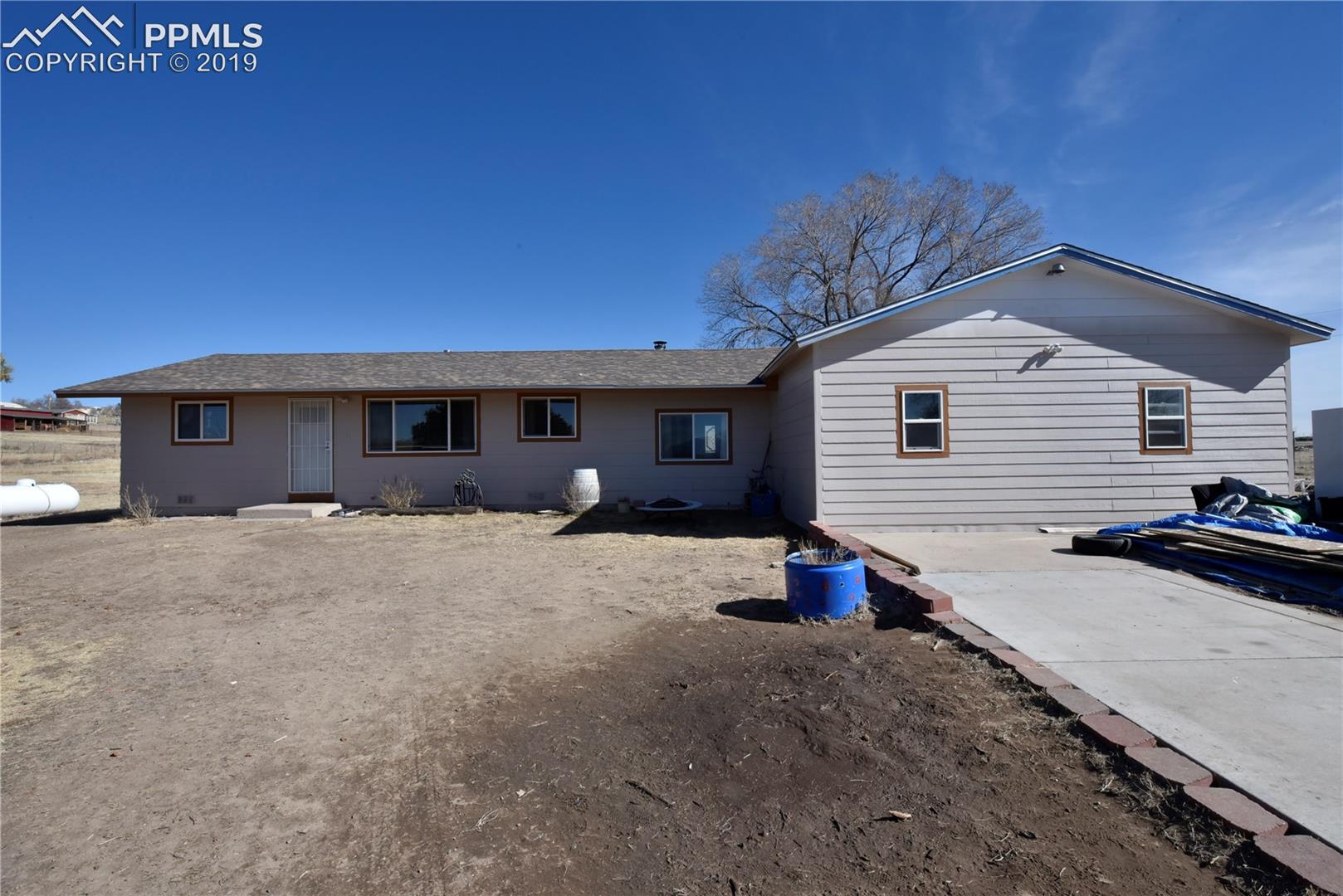 Front of home with partial concrete driveway, then dirt and gravel toward street