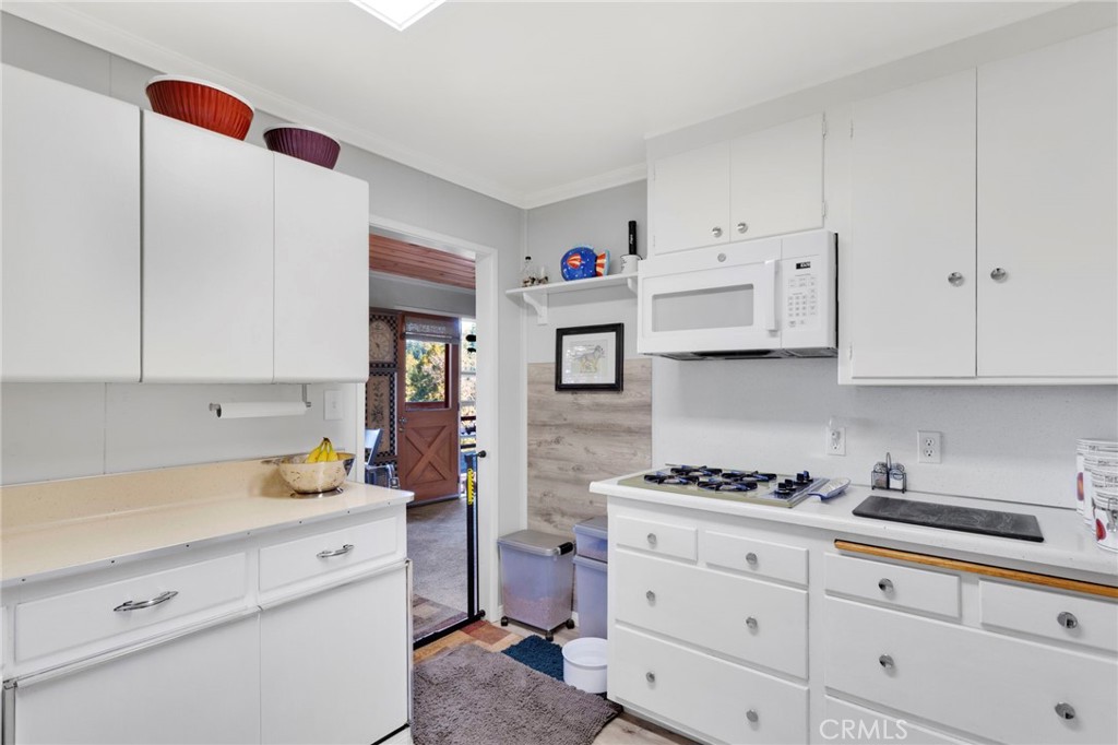 993 Mercury Way Crestline, CA 92325 - Photo 23 of 68 a kitchen with granite countertop white cabinets and white appliances