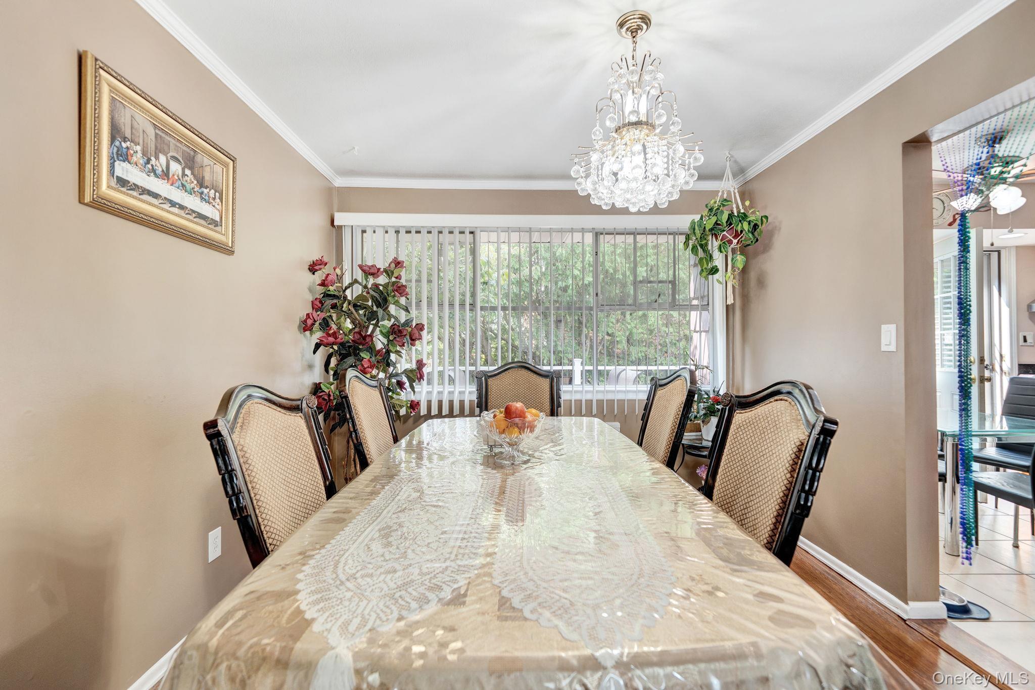 1 Wayland Road Plainview, NY 11803 - Photo 14 of 28 Dining room featuring ornamental molding, a chandelier, and wood finished floors