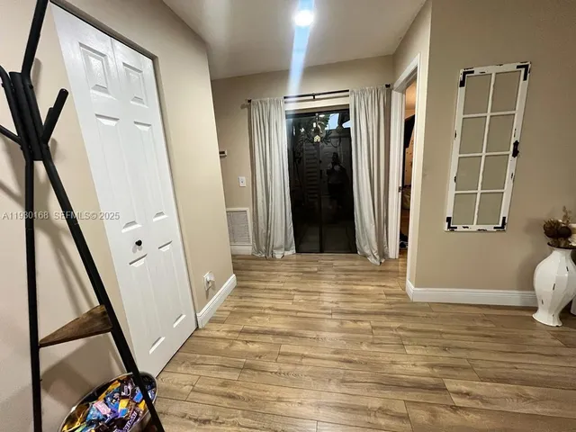 a view of a hallway with wooden floor and staircase