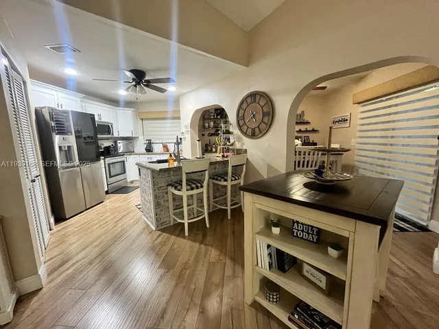 a kitchen with stainless steel appliances a dining table chairs and a stove