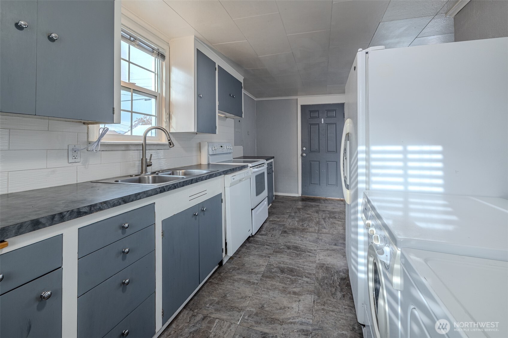 246 North Delaware Avenue Wenatchee, WA 98801 - Photo 12 of 26 a large white kitchen with granite countertop a sink and dishwasher a stove a refrigerator with wooden cabinets
