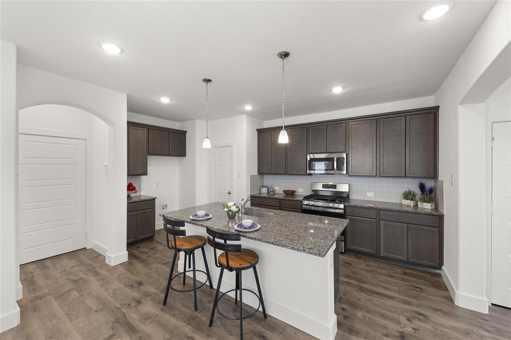 1402 Apricot Lane Gainesville, TX 76240 - Photo 5 of 11 a kitchen with kitchen island a sink stove and refrigerator