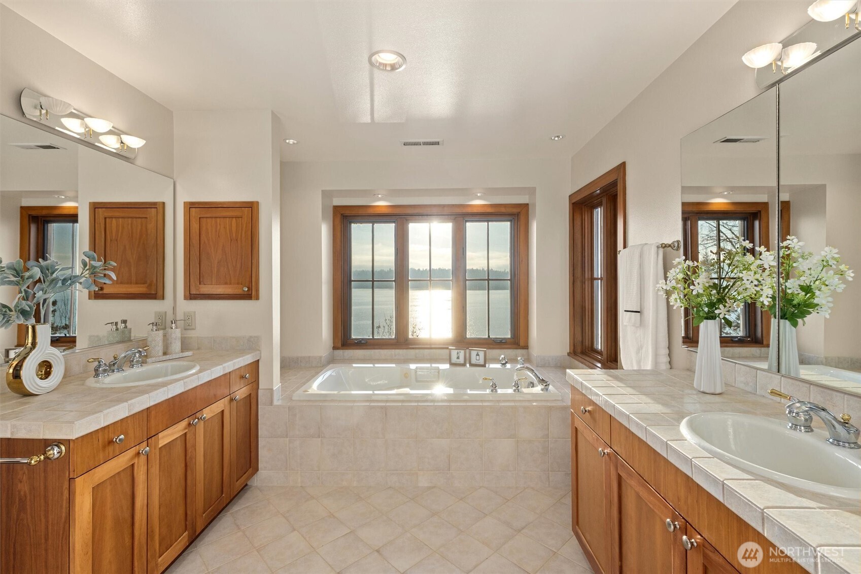 8281 West Mercer Way Mercer Island, WA 98040 - Photo 23 of 38 a spacious bathroom with a granite countertop double vanity sink a large mirror and a bathtub