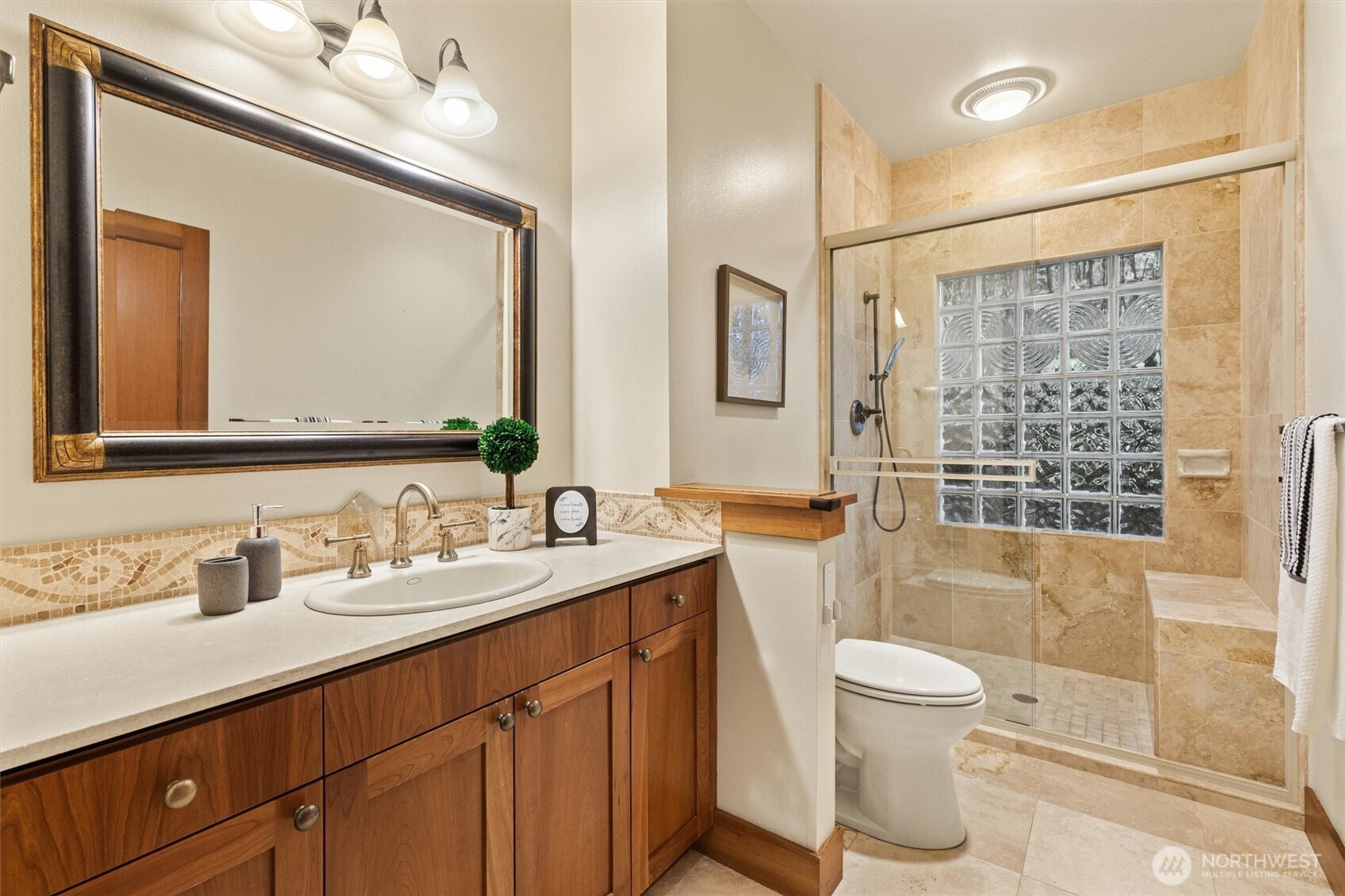 8281 West Mercer Way Mercer Island, WA 98040 - Photo 31 of 38 a bathroom with a double vanity sink toilet mirror and shower