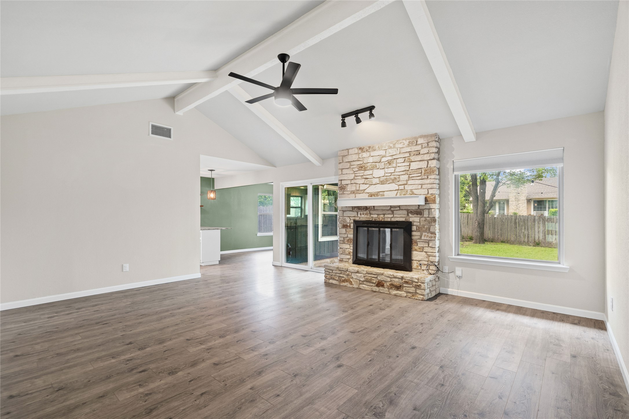 810 Stillhouse Spring Round Rock, TX 78681 - Photo 6 of 18 A spacious living room showcasing vaulted ceilings, a cozy stone fireplace, and ample natural light.