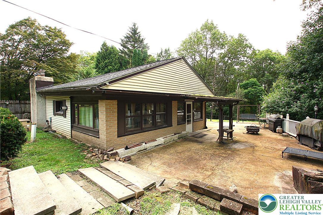a view of a house with a yard and sitting area
