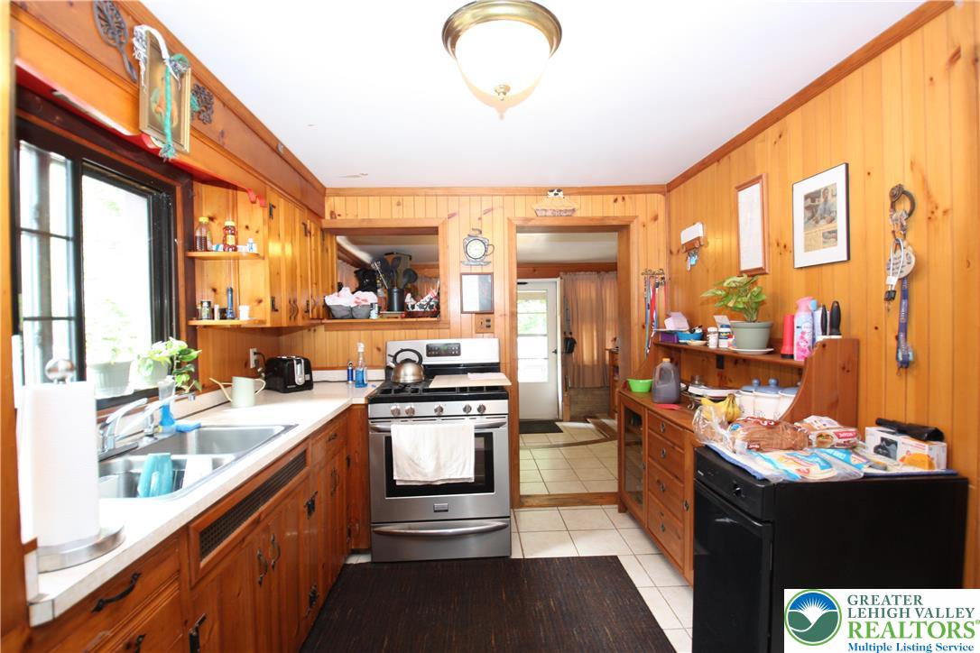 305 Cedar Hill Road Effort, PA 18330 - Photo 9 of 20 a kitchen with stainless steel appliances granite countertop a sink stove and cabinets