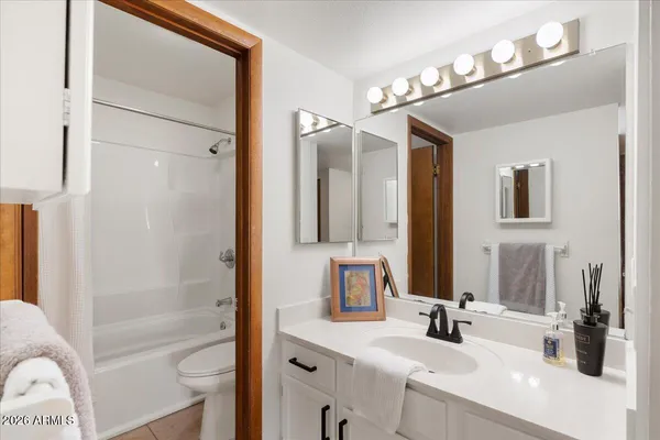 a bathroom with a tub a sink and a mirror