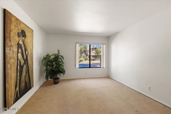 an empty room with windows and plants