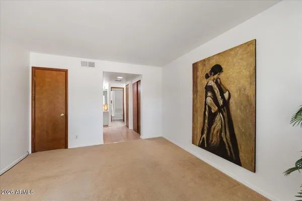 a view of a hallway and closet with wooden floor