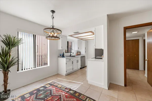 a kitchen that has a lot of white cabinets and stainless steel appliances