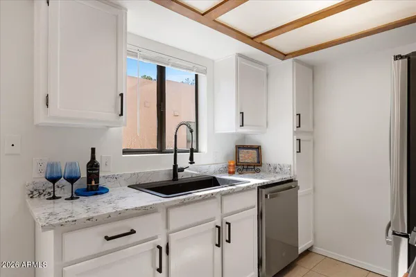 a kitchen with stainless steel appliances granite countertop a sink a stove and white cabinets