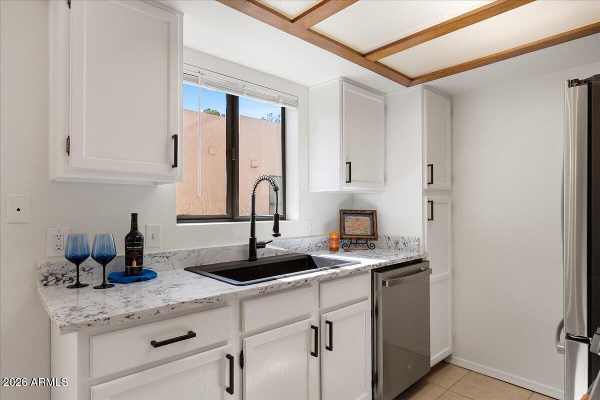 65 Verde Valley School Road, Unit H10 Sedona, AZ 86351 - Photo 9 of 20 a kitchen with stainless steel appliances granite countertop a sink a stove and white cabinets